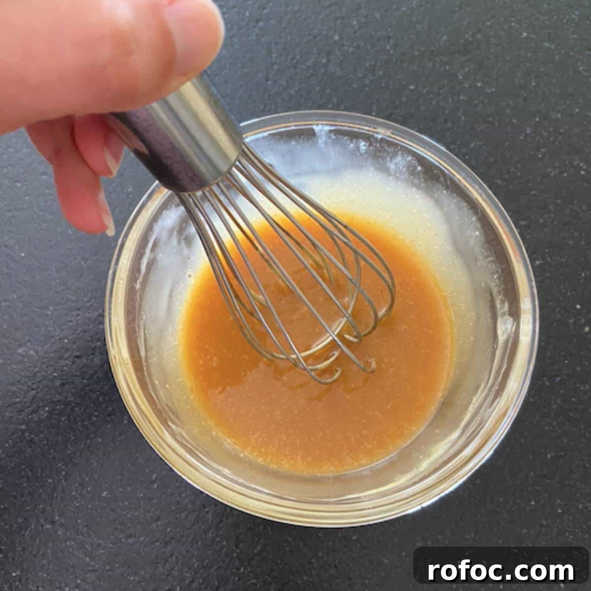 Sweet Heat Honey Mustard Sauce Recipe 4 hand whisking honey mustard in glass bowl