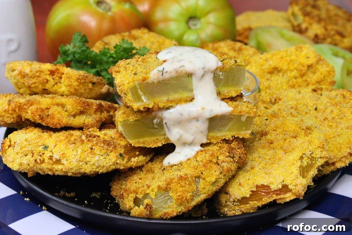 11 Creative Air Fryer Tomato Recipes for Flavorful Meals 6 closeup view of air fryer fried green tomatoes on a plate with one cut in half dripping with hot honey ranch