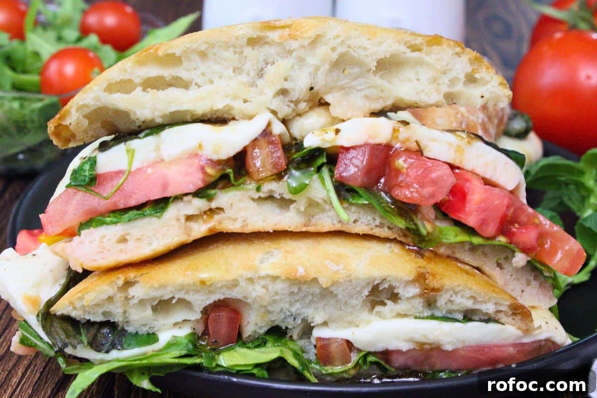 11 Creative Air Fryer Tomato Recipes for Flavorful Meals 8 two halves of caprese sandwich stacked on top of each other showing tomatoes mozzarella cheese and fresh greens