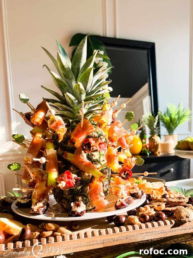 9 Tropical Cocktail Appetizers for Your Next Party 2 Fresh pineapple as a centerpiece on a cocktail party table displaying assorted appetizers on cocktail picks.