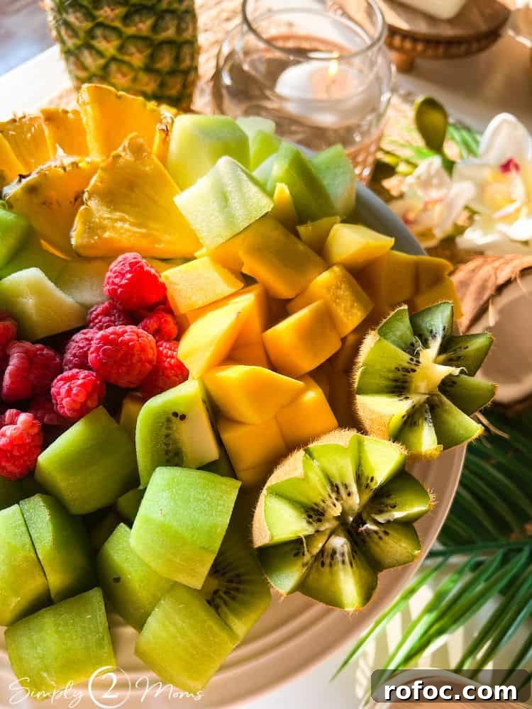 9 Tropical Cocktail Appetizers for Your Next Party 3 Plate of cut tropical fruit including kiwi, pineapple, mango, melon, and raspberries for a cocktail party.