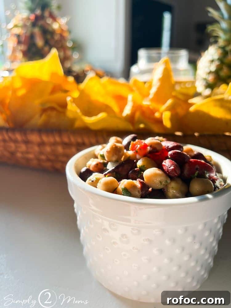 9 Tropical Cocktail Appetizers for Your Next Party 6 Ramekin of Caribbean bean salad with a basket of tortilla chips for a tropical cocktail party appetizer.