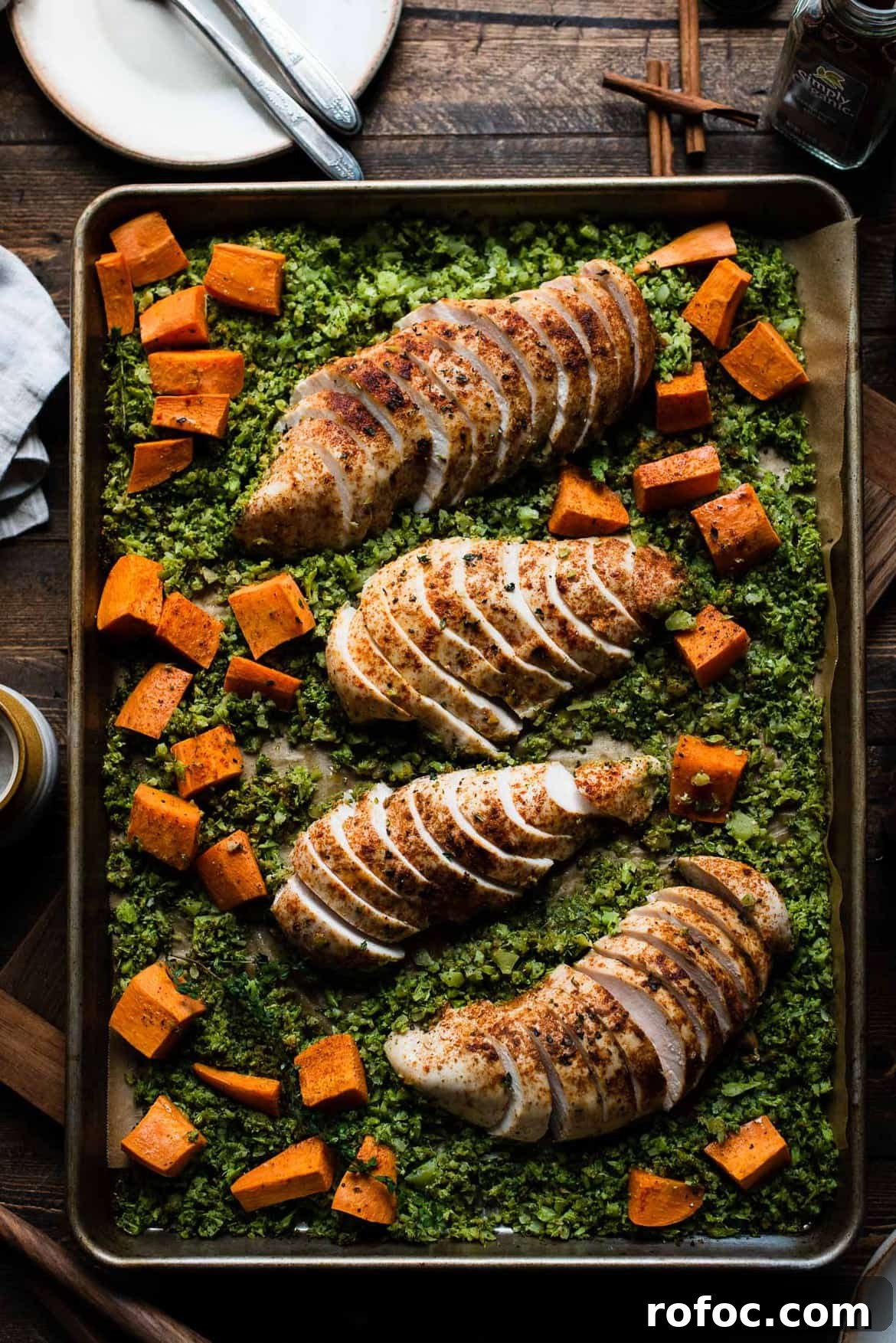 Sheet-Pan Moroccan Chicken with Broccoli Rice & Roasted Sweet Potatoes 2 Baked broccoli rice, sweet potatoes, and chicken breast on a large baking tray.