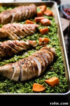 Sheet-Pan Moroccan Chicken with Broccoli Rice & Roasted Sweet Potatoes 10 A sliced seasoned chicken breast surrounded by broccoli rice and sweet potato chunks.