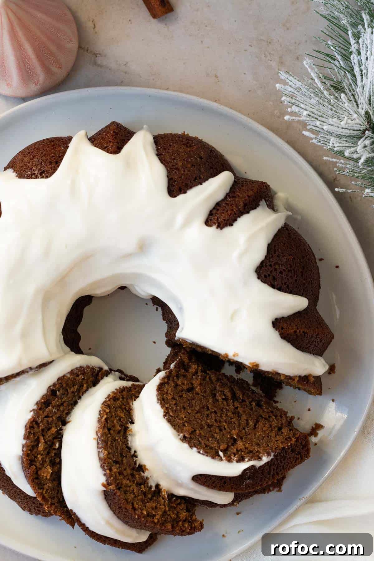 Gingerbread Bundt Cake with Silky Cream Cheese Glaze 6 gingerbread bundt cake with a cream cheese glaze on a gray plate sitting on a light brown background