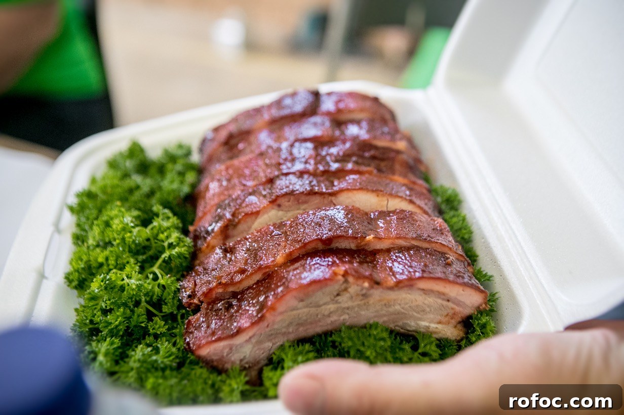 5 Pro Tips to Build a Winning Barbecue Competition Box 2 baby backs in hand in competition box parsley