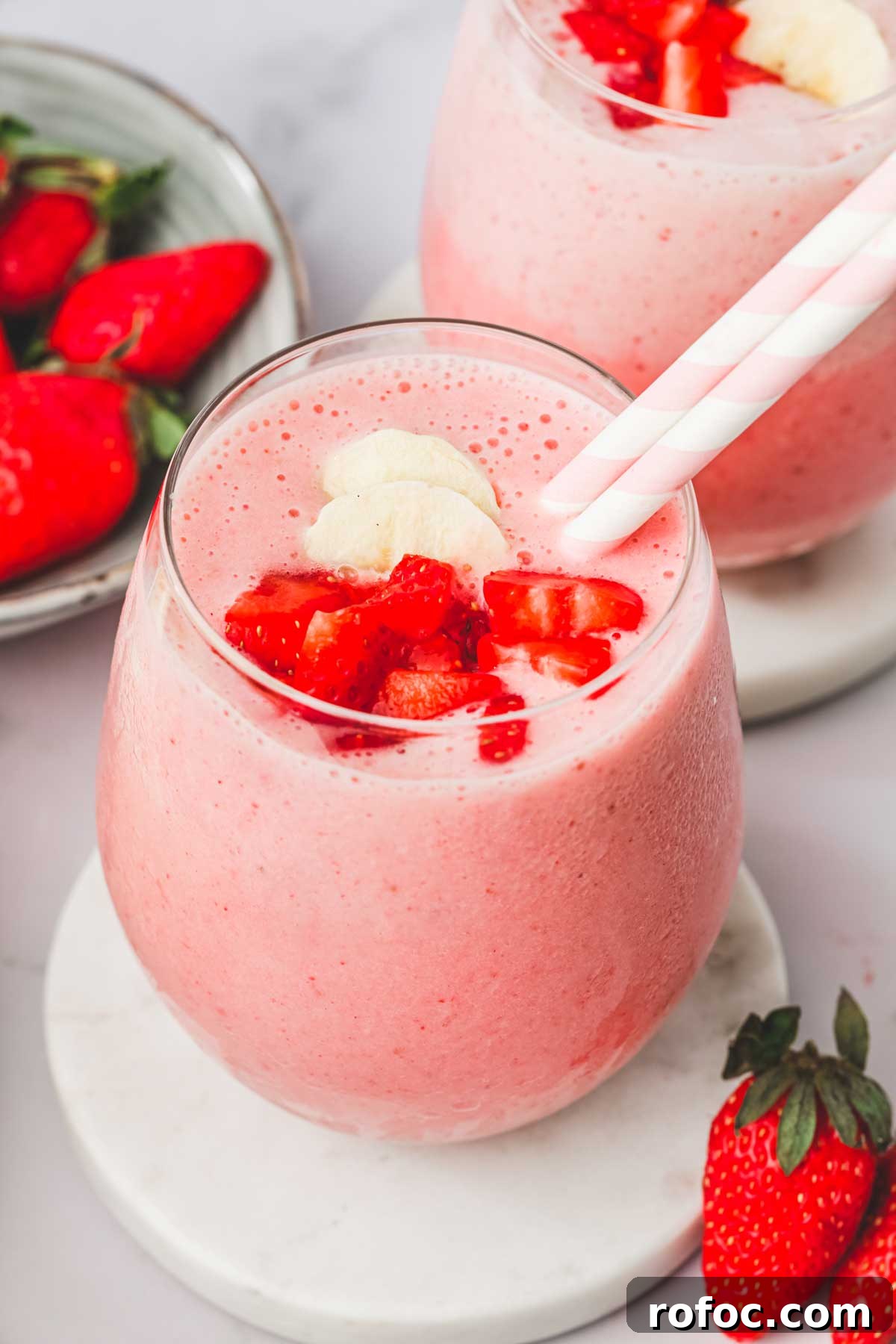 Strawberry Banana Smoothie Recipe — Creamy Fresh Blend 2 2 verres avec du smoothie à la fraise et banane avec des pailles