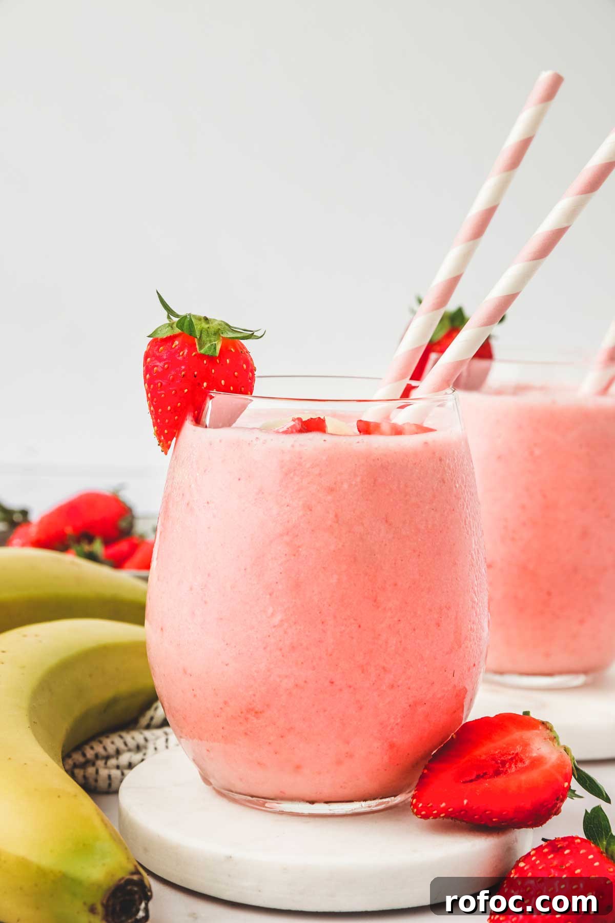 Strawberry Banana Smoothie Recipe — Creamy Fresh Blend 7 2 verres remplis de smoothie fraise banane et des pailles