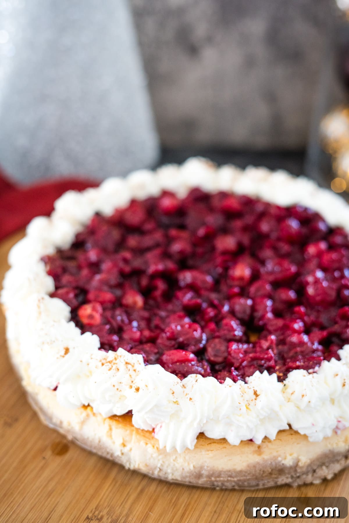 Low-Carb Cranberry Cheesecake: Keto Holiday Dessert Recipe 2 A cranberry cheesecake on a wooden cutting board.