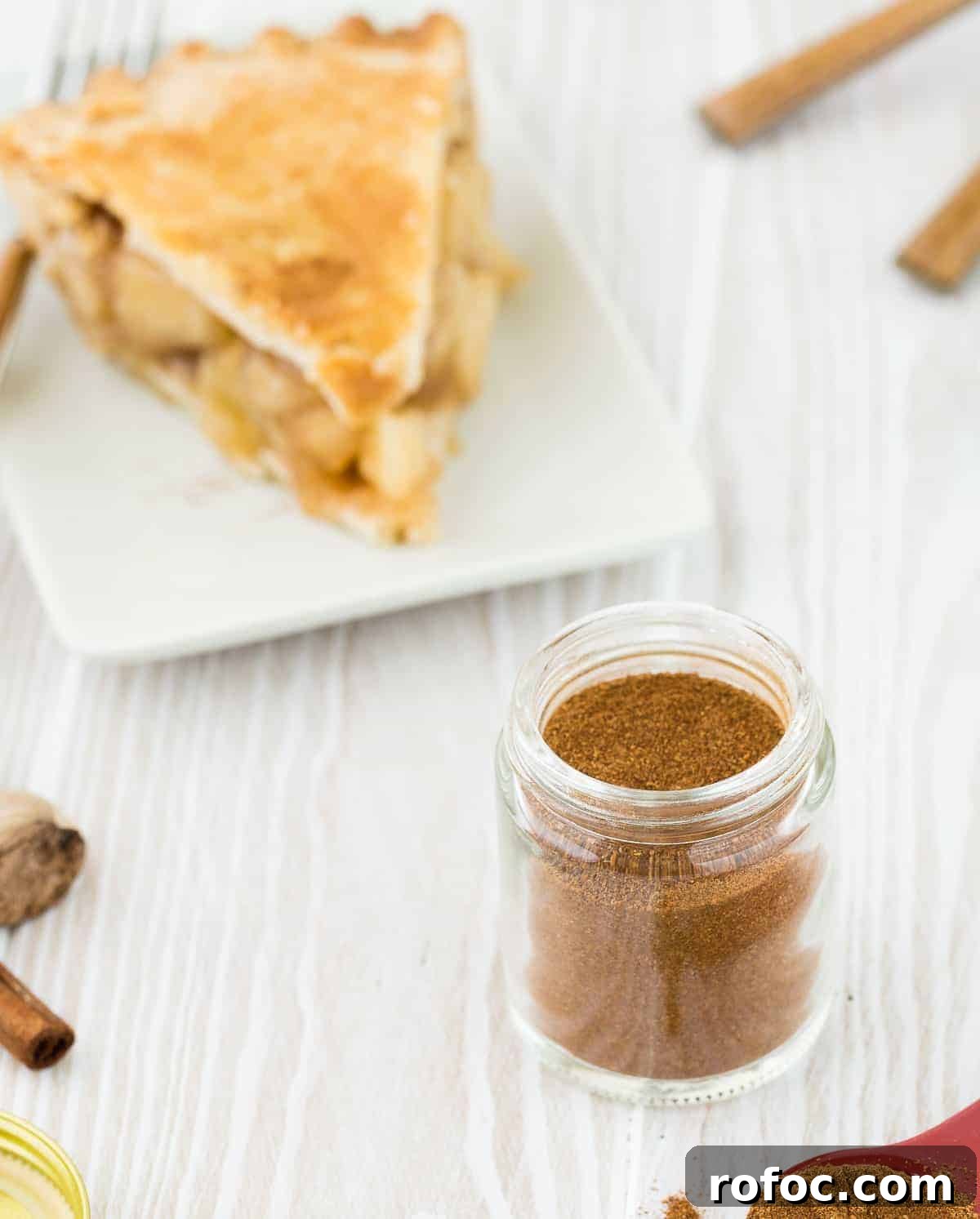 Homemade Apple Pie Spice Mix You Can Make in Minutes 5 Apple pie on a white plate, with apple pie spices in the foreground.