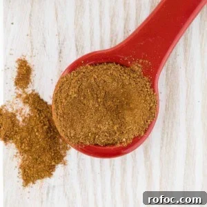 Homemade Apple Pie Spice Mix You Can Make in Minutes 7 Overhead view of apple pie spice on a red ceramic measuring spoon.
