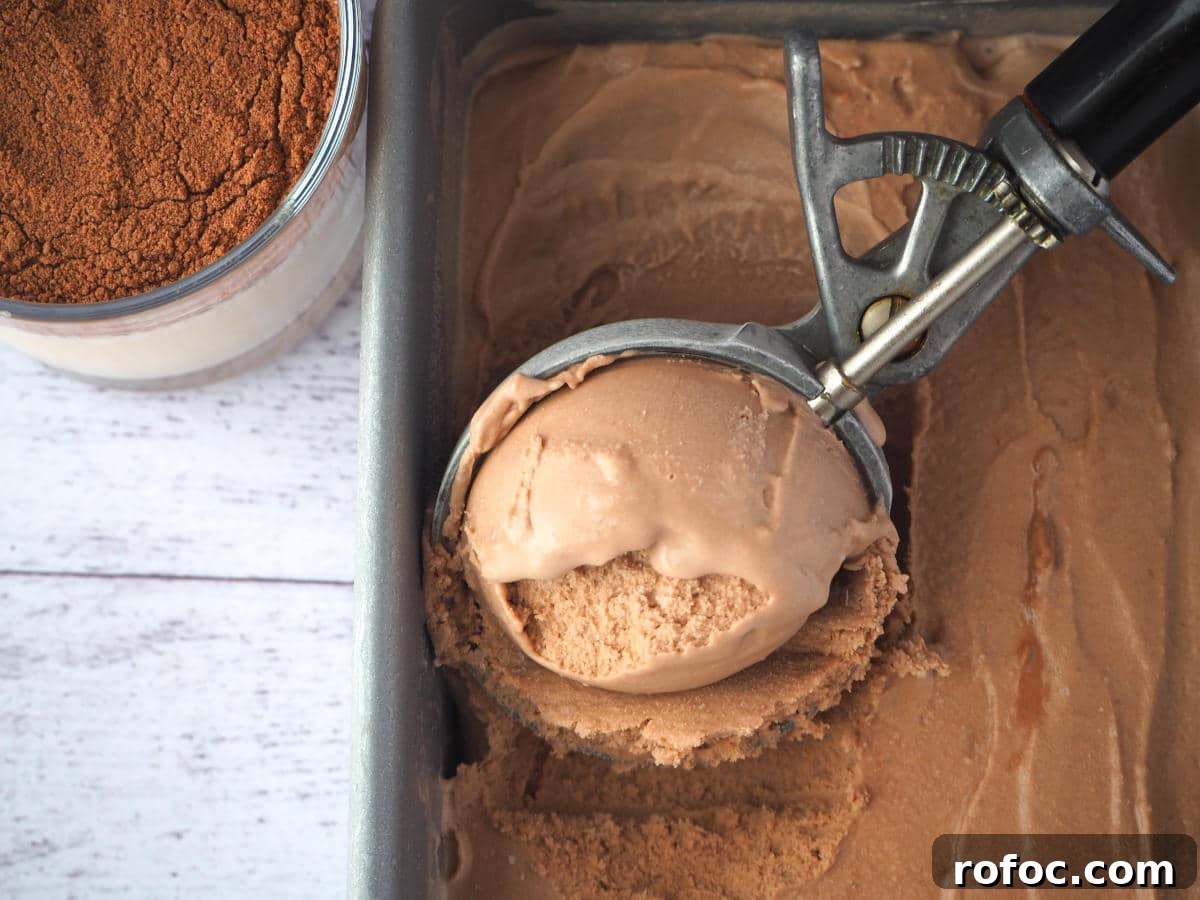 Creamy Milo Ice Cream Recipe: Homemade Milo Frozen Treat 11 Top down view scooping Milo ice cream in a pan with vintage ice cream scoop, with glass of Milo on the side.