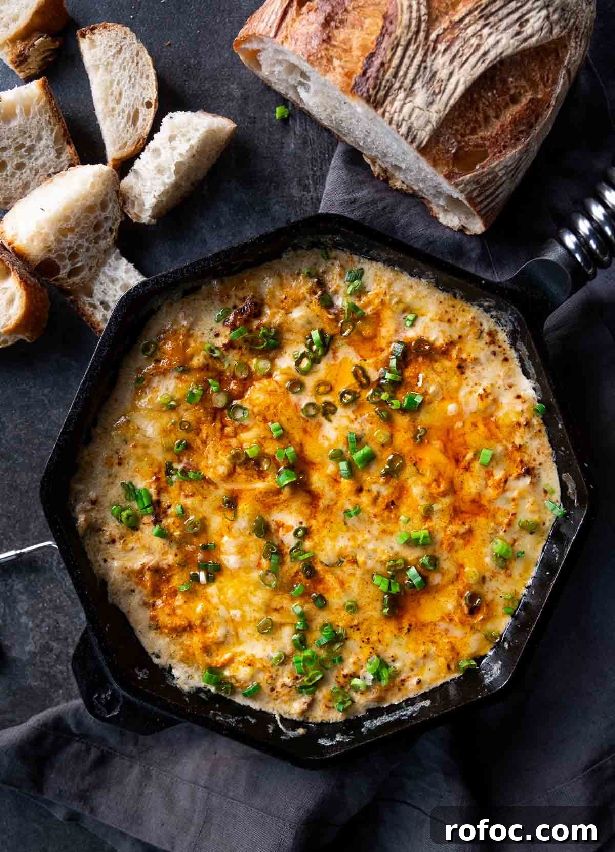 Dungeness Crab Dip That Pairs Perfectly for Parties 2 Hot Crab Dip made with Dungeness Crab and Smoked Salmon in a cast iron pan, topped with scallions.