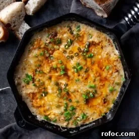 Dungeness Crab Dip That Pairs Perfectly for Parties 7 Crab dip with Dungeness crab and smoked salmon in a large cast iron pan surrounded by fresh slices of bread.