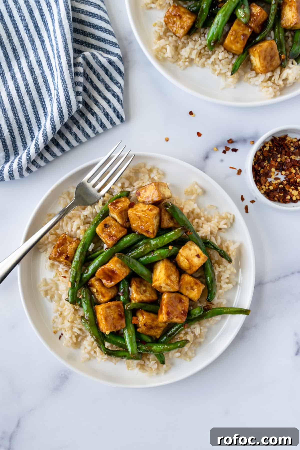 Teriyaki Tofu Stir-Fry with Crispy Green Beans 2 Teriyaki Tofu Stir Fry with Green Beans on a white plate with crushed red pepper.