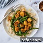 Teriyaki Tofu Stir Fry with Green Beans on a white plate with a fork.