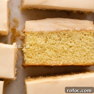 Rectangular slices of butterscotch krimpets placed on a parchment paper lined background with center slice on its side.