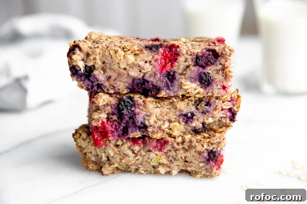 Vegan Gluten-Free Baked Oatmeal Bars Made with Natural Sweeteners 2 Close-up side angle shot of three oatmeal bars stacked on top of one another.