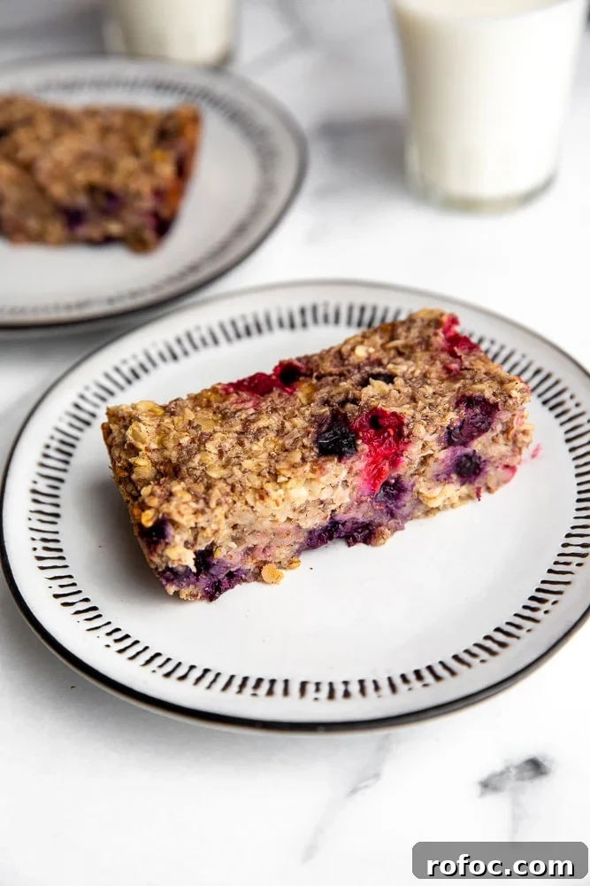 Vegan Gluten-Free Baked Oatmeal Bars Made with Natural Sweeteners 3 Baked oatmeal bar on plate with glass of milk in the background.