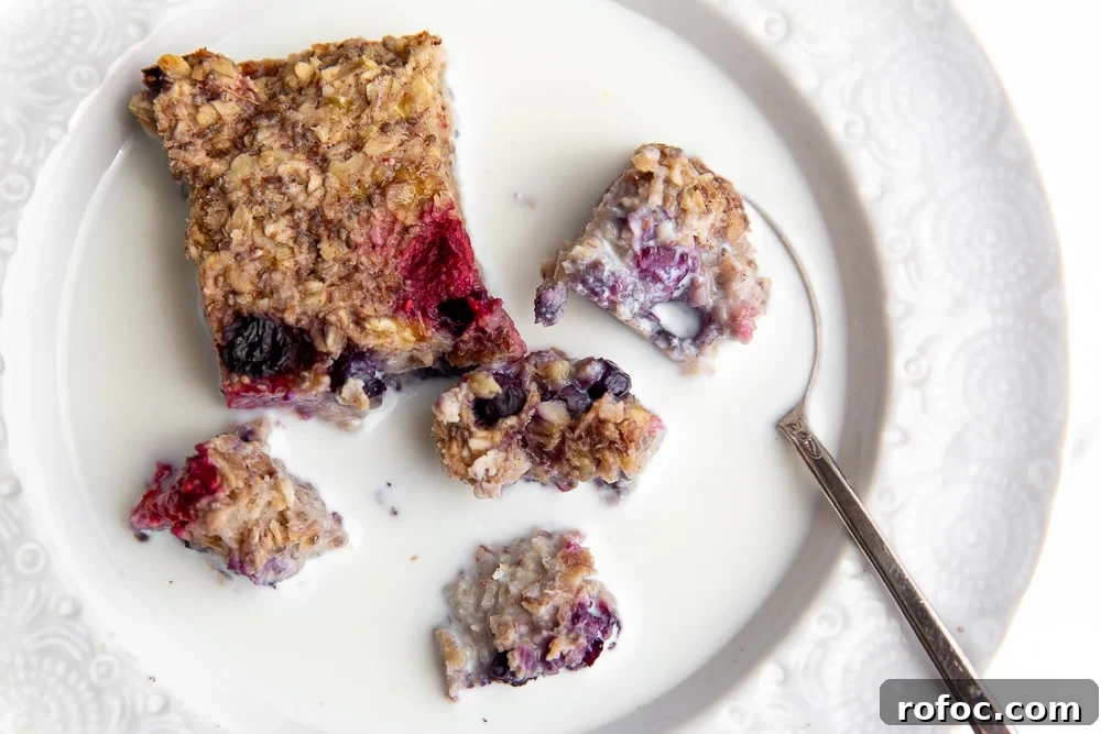 Vegan Gluten-Free Baked Oatmeal Bars Made with Natural Sweeteners 8 Baked oatmeal bar broken up in a bowl with milk and a spoon.