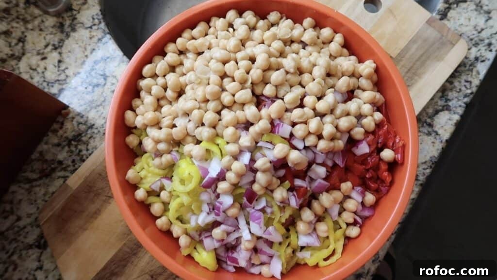 La Scala Pasta Salad Recipe: Classic Italian-Inspired Dish 11 Adding the diced red onion, sliced banana peppers, roasted red peppers, diced provolone, diced charcuterie meat (such as salami, soppressata, and/or pepperoni), and chickpeas to the bowl with the pasta
