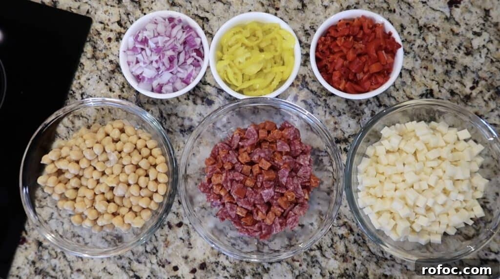 La Scala Pasta Salad Recipe: Classic Italian-Inspired Dish 8 Bowls featuring diced red onion, sliced banana peppers, roasted red peppers, diced provolone, diced charcuterie meat (such as salami, soppressata, and/or pepperoni), and chickpeas.