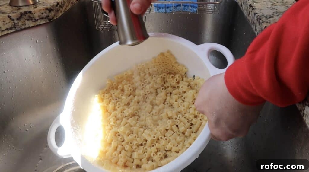 La Scala Pasta Salad Recipe: Classic Italian-Inspired Dish 9 Rinsing cooked pasta under cold water in a colander in the sink
