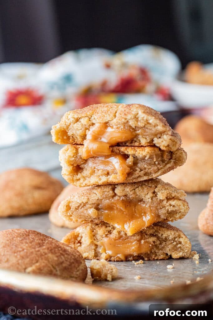 Caramel-Filled Snickerdoodles: Gooey Cinnamon Cookie Recipe 5 Stack of baked caramel stuffed cookie halves on metal pan.