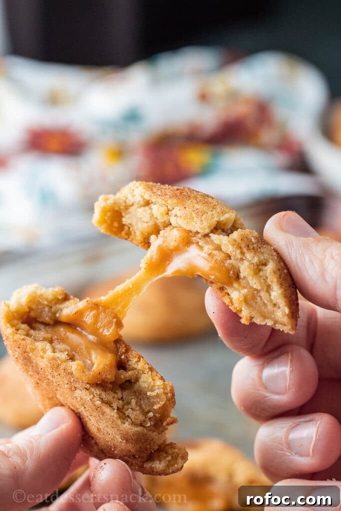 Caramel-Filled Snickerdoodles: Gooey Cinnamon Cookie Recipe 6 Hands pulling caramel stuffed cookie apart with caramel in middle.