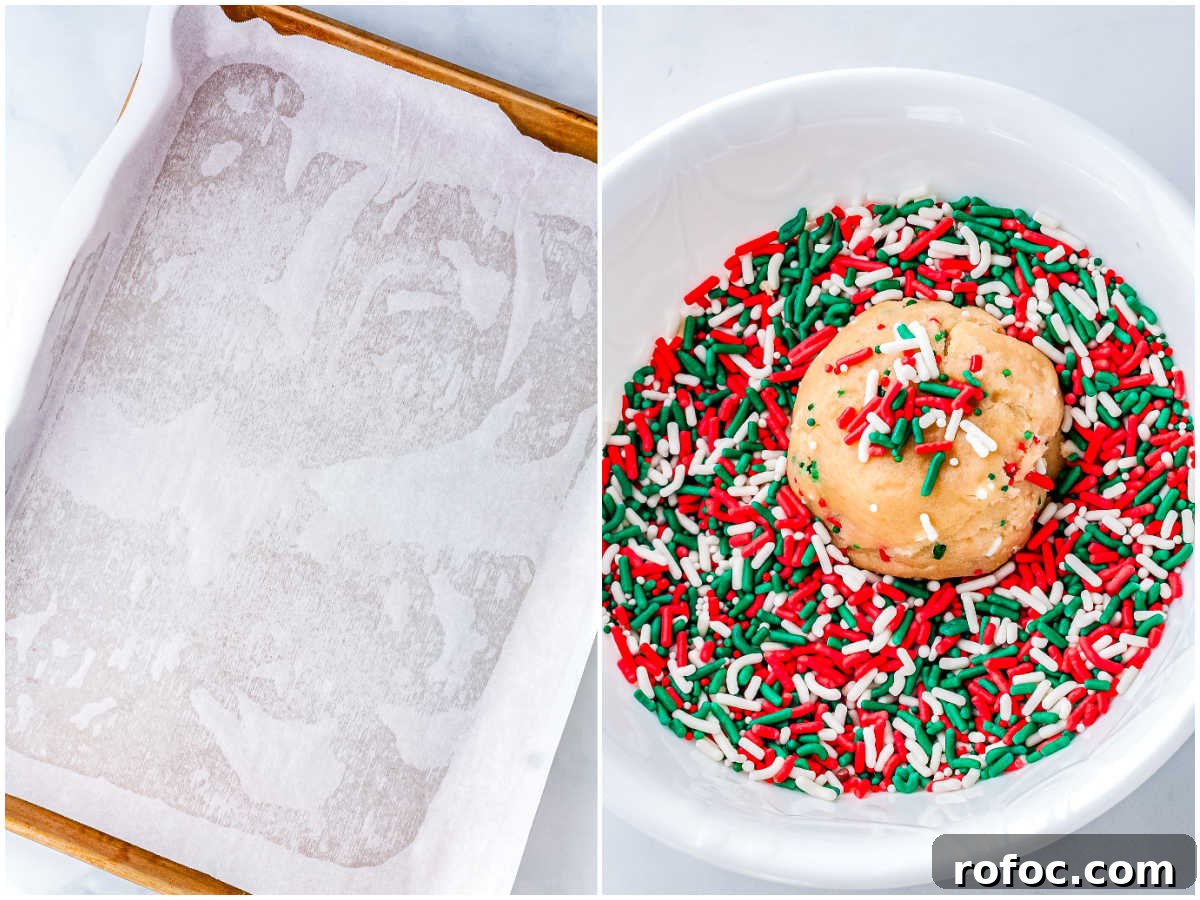Cookie dough ball rolled in colorful holiday sprinkles beside a parchment-lined baking sheet ready for baking festive sugar cookies.