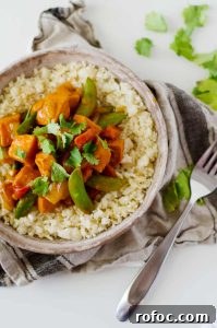Vegetarian Red Curry Stir-Fry with Vegetables and Tofu 2 Vegetarian Red Curry Stir Fry - a Bowl Full of Stir Fry with a Fork Next to It and a Cloth Beneath