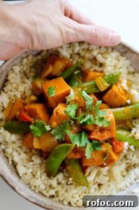 Vegetarian Red Curry Stir-Fry with Vegetables and Tofu 4 Vegetarian Red Curry Stir Fry - Holding a Bowl Full of the Meal in a Hand