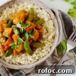 Vegetarian Red Curry Stir-Fry with Vegetables and Tofu 5 Vegetarian Red Curry Stir Fry - a Bowl Full of Stir Fry with a Fork Next to It and a Cloth Beneath