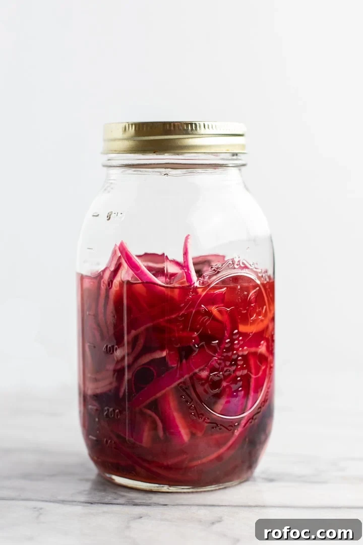 30-Minute Vegetarian Taco Recipe for Busy Weeknights 4 A mason jar filled with pickled onions on a white background.