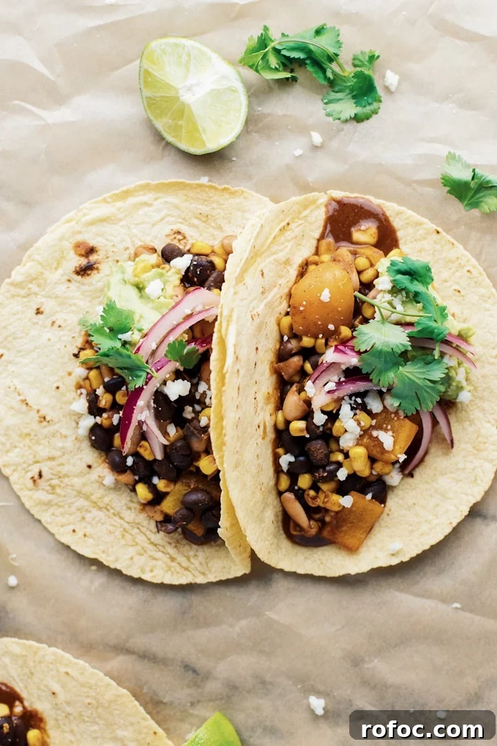 30-Minute Vegetarian Taco Recipe for Busy Weeknights 5 Vegetarian tacos on brown parchment paper with cilantro and lime laid out around it.