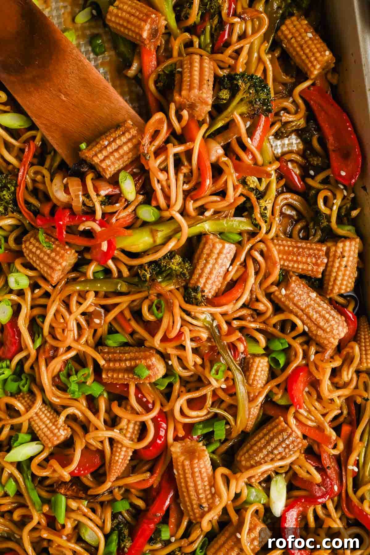 Crispy Sheet-Pan Chow Mein: Quick One-Pan Asian Noodle Bake 8 sheet pan chow mein with broccoli, peppers and corn mixed on gold baking sheet.