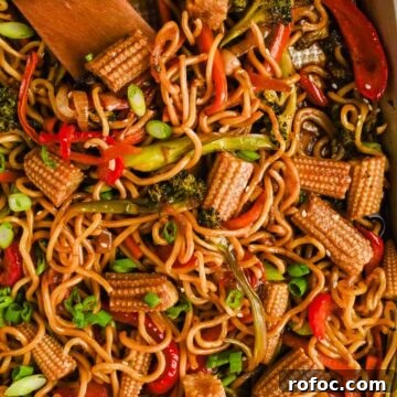 Crispy Sheet-Pan Chow Mein: Quick One-Pan Asian Noodle Bake 9 sheet pan chow mein with broccoli, peppers and corn mixed on gold baking sheet.