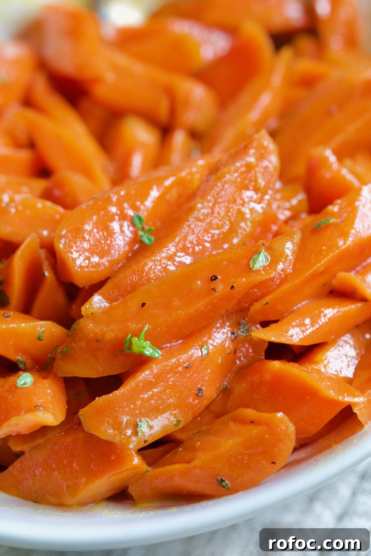 Bourbon-Glazed Carrots with Honey and Fresh Thyme 11 Bourbon-Glazed Carrots with Honey in white serving bowl.