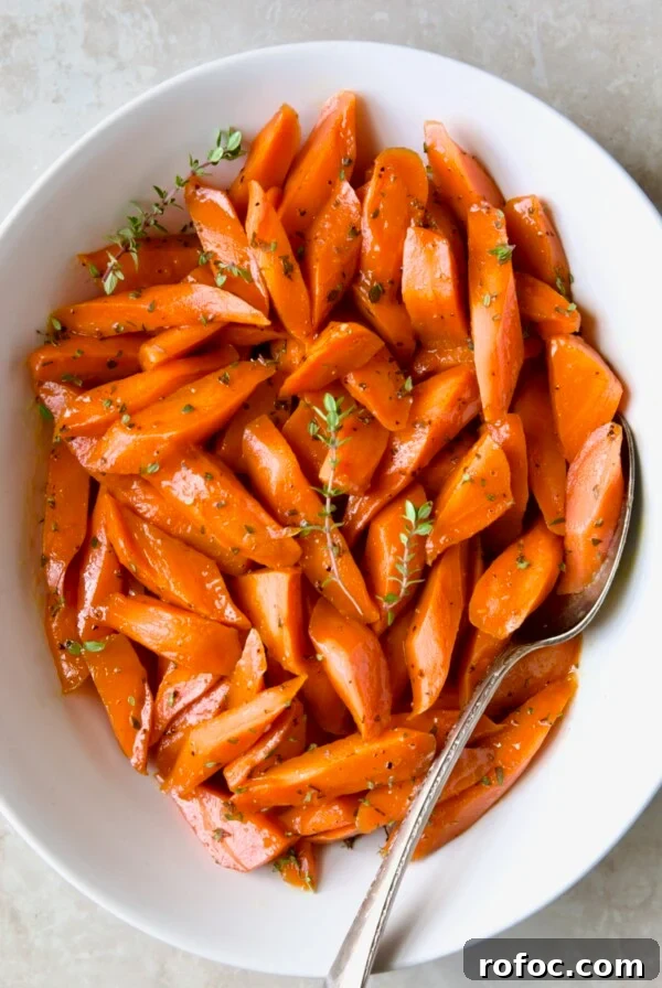 Bourbon-Glazed Carrots with Honey and Fresh Thyme 13 Bourbon-Glazed Carrots with Honey in white serving bowl with fresh thyme.