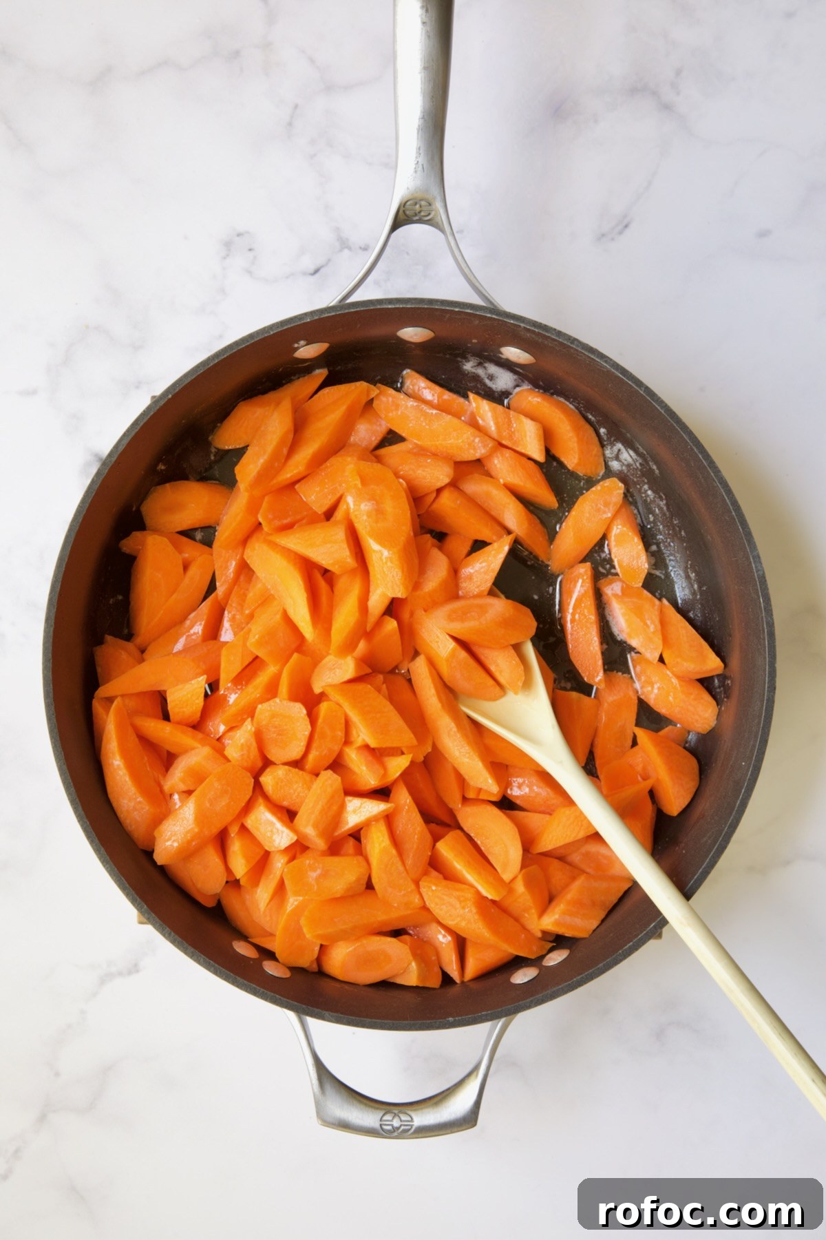 Bourbon-Glazed Carrots with Honey and Fresh Thyme 7 Carrots being sauteed in butter in nonstick skillet.