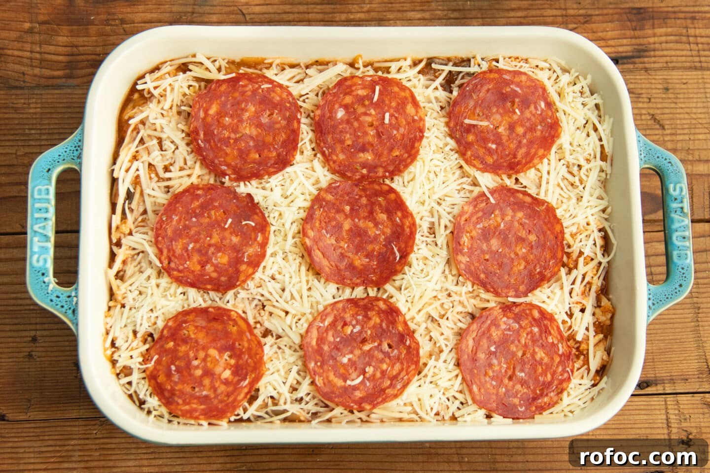 This is a picture of the baking dish with the chicken and squash mixture, cheese and pepperoni on top.