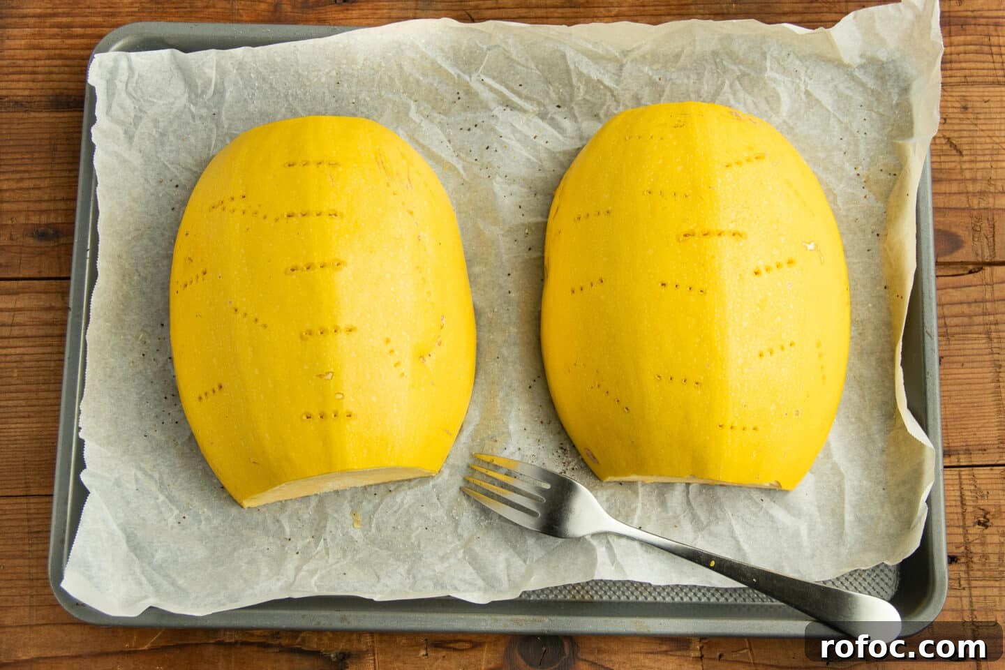 This is a picture of the two halves of the squash flesh down on the baking sheet.