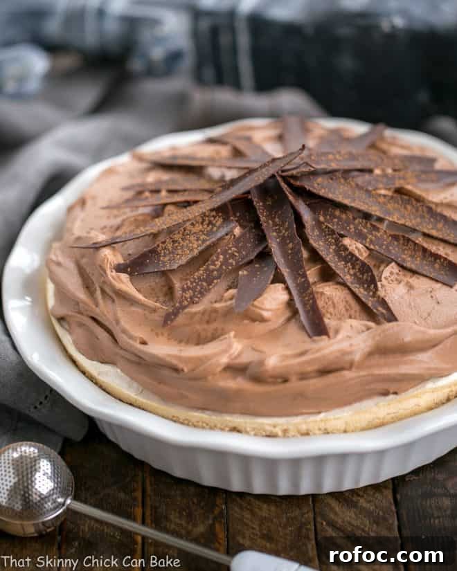 Chocolate Velvet Pie with Meringue Crust, a dreamy gluten free chocolate pie Chocolate Velvet Pie with Meringue Crust in white pie plate topped with chocolate shards and dusted with cocoa powder
