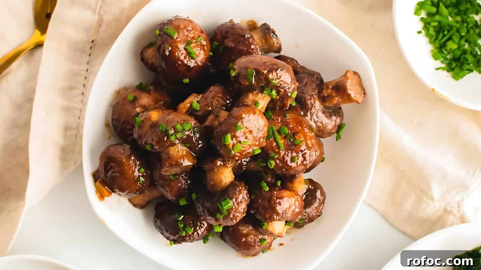 23 Vegetarian Dinners That Even Meat Eaters Will Love 12 A white bowl filled with glazed mushrooms garnished with chopped green herbs.
