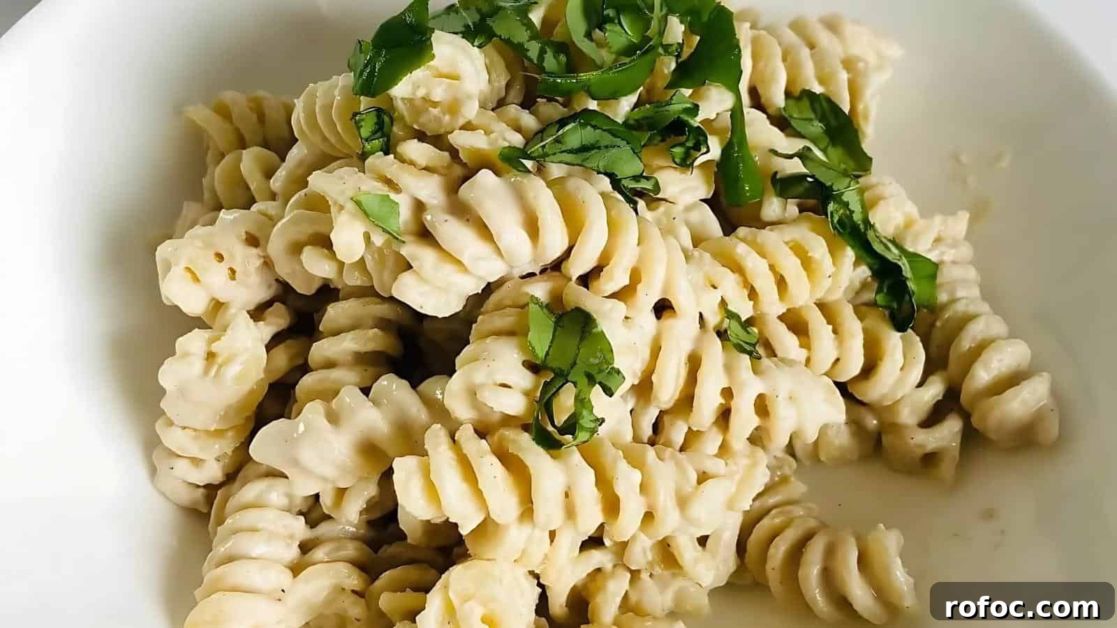 23 Vegetarian Dinners That Even Meat Eaters Will Love 23 A plate of fusilli pasta is topped with creamy white sauce and garnished with chopped green herbs.