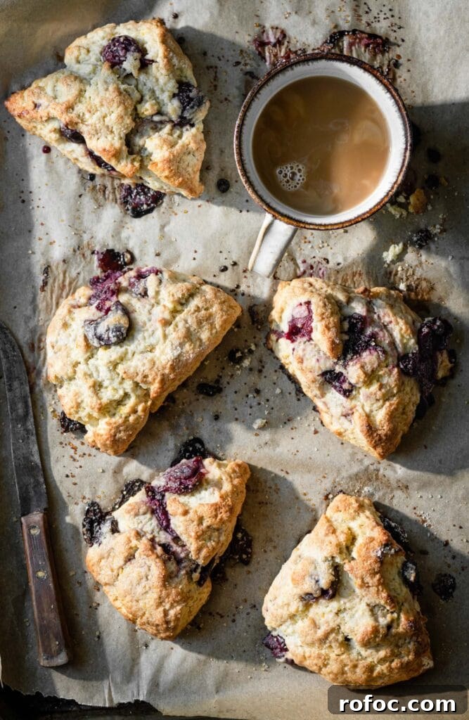 Fresh Cherry Scones: Flaky Homemade Recipe for Summer Baking 12 Baking tray with five cherry scones and a cup of coffee.