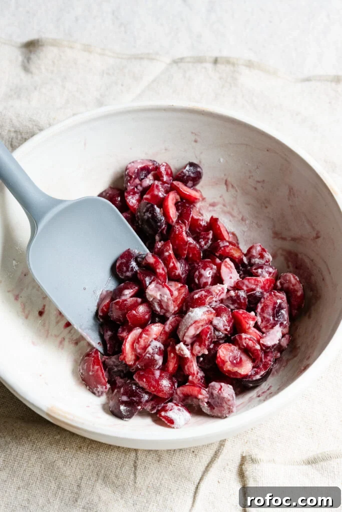 Fresh Cherry Scones: Flaky Homemade Recipe for Summer Baking 4 Chopped cherries in a bowl with a spatula.