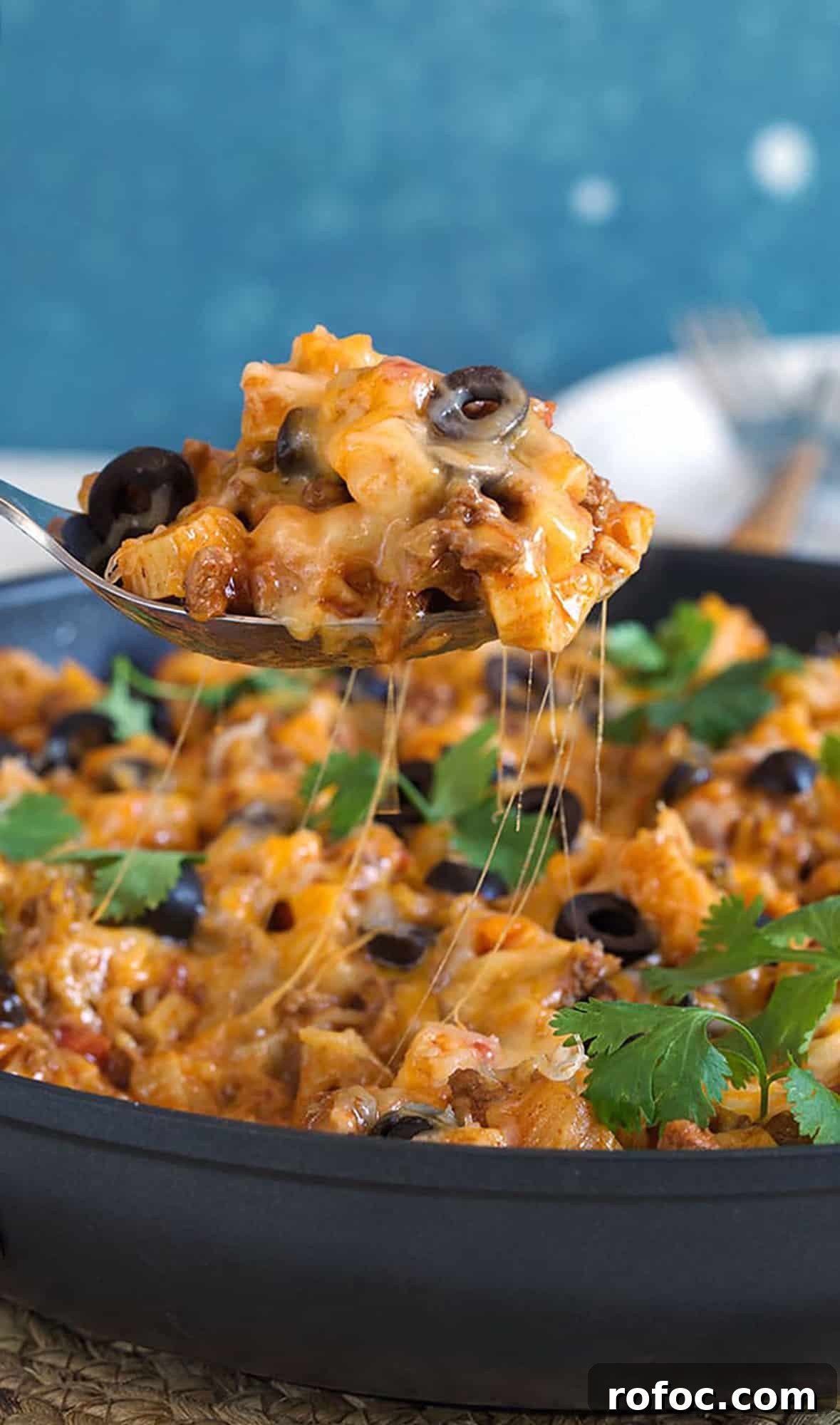 Cheesy Taco Pasta Recipe: One-Pot Mexican-Inspired Dinner 4 taco pasta being served with a wooden spoon.