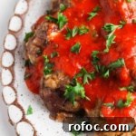 Gluten-Free Meatballs: Savory, Tender Recipe for Dinner 10 Gluten free meatballs on a white plate covered in red sauce and parsley.