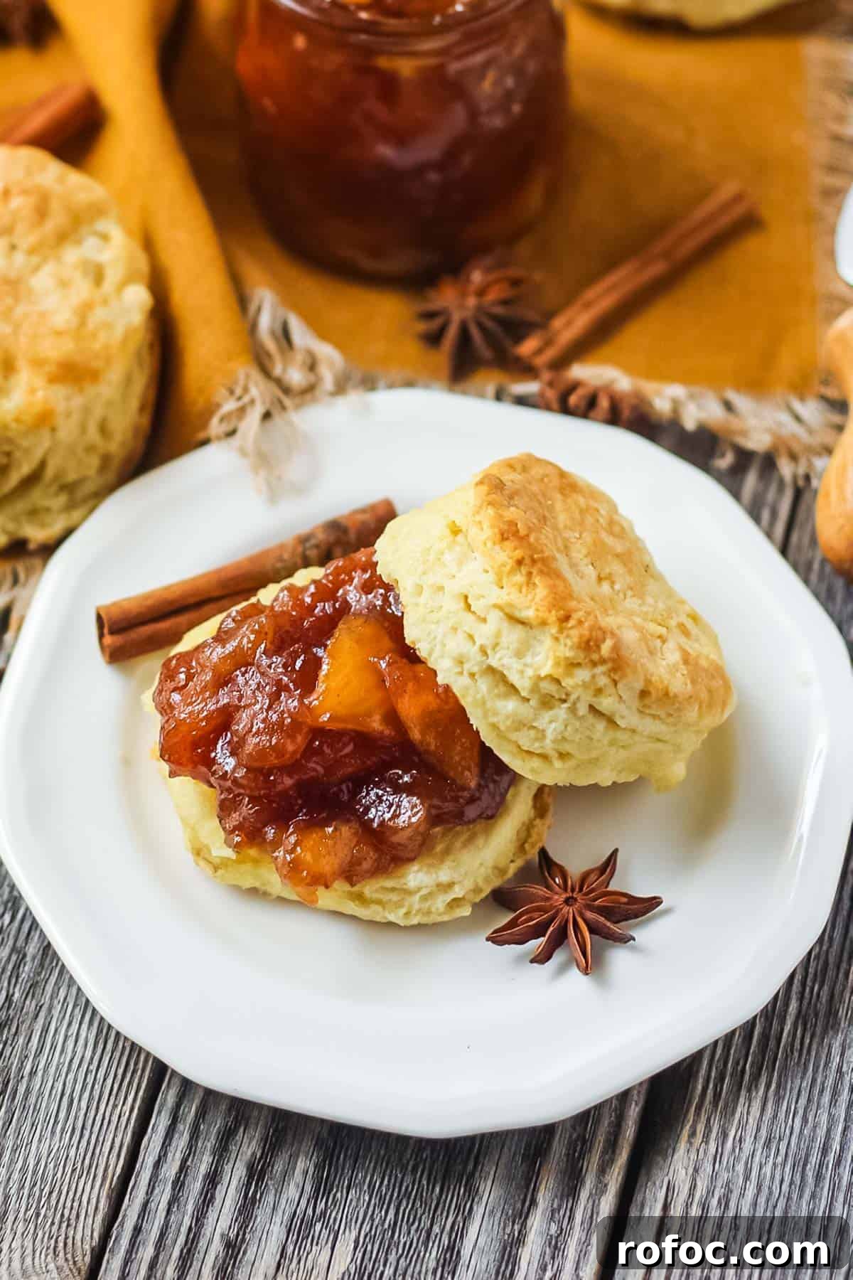 How to Make Classic Homemade Apple Jam: Simple Step-by-Step Recipe 3 apple jam on a sliced buttermilk biscuit on a white plate.